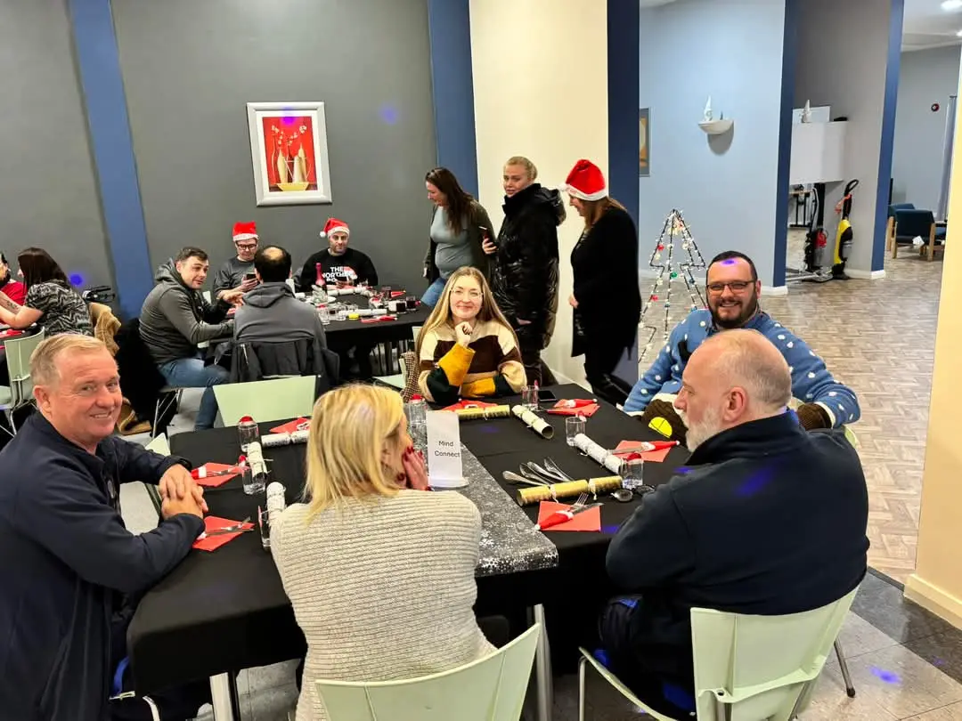 People chatting around tables at a Mind Connect community session