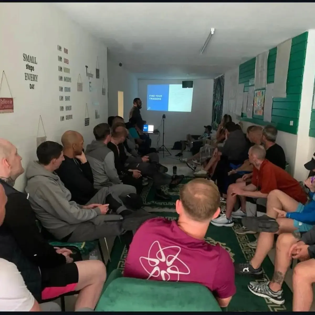 People sitting together at a Mind Connect group session, listening to a talk
